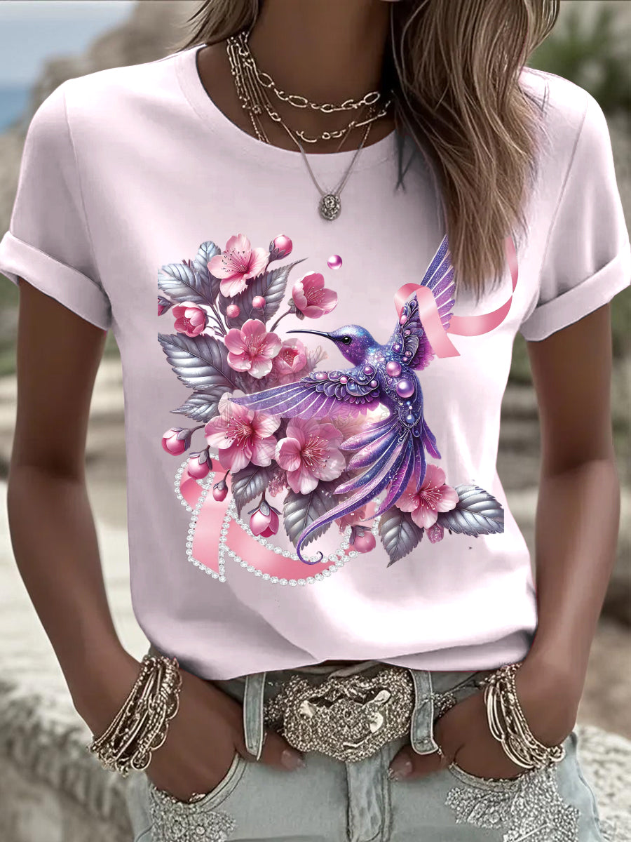 Γυναικείο ευρωπαϊκό στυλ ροζ T-shirt, με εντυπωσιακό κολιμπρί, λουλούδια και κορδέλα πρόληψης καρκίνου του μαστού, δείχνει κομψό αίσθημα στην καθημερινή φθορά